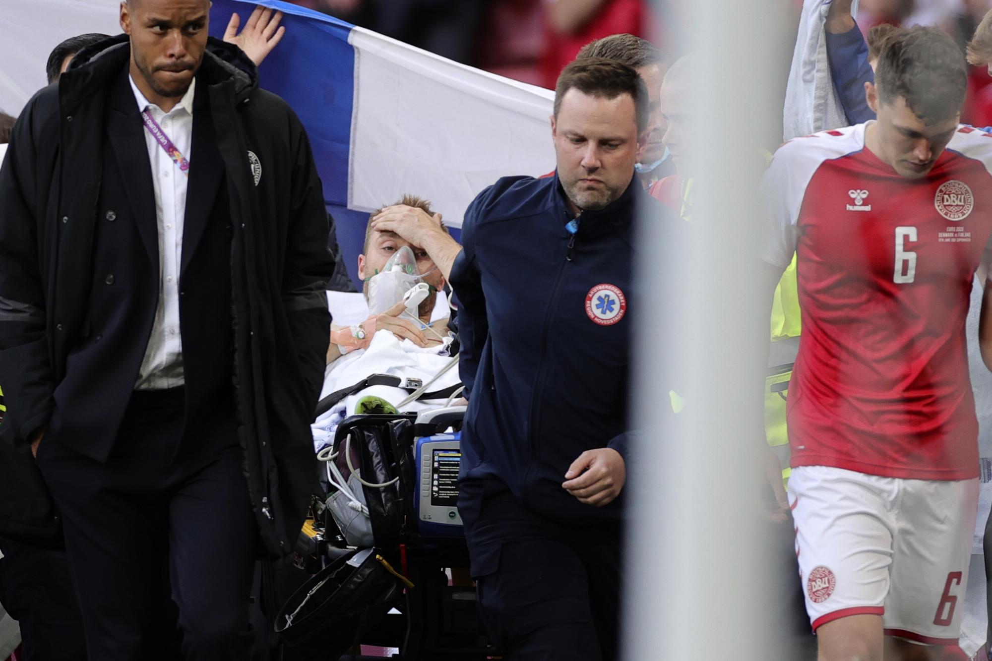 Paramédicos retiran en camilla al jugador danés Christian Eriksen, quien se desvaneció en un partido de la Eurocopa frente a Finlandia, el sábado 12 de junio de 2021, en Copenhague (AP/Friedemann Vogel)