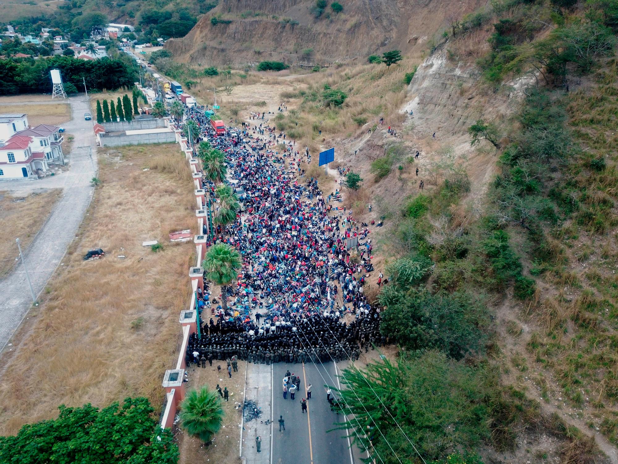 Soldados y policías guatemaltecos forman una barricada humana para detener a los migrantes hondureños que caminan por una carretera hoy, en Chiquimula (Guatemala).