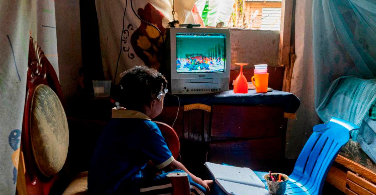 Una niña mira por un televisor las clases de su grado que transmite el Ministerio de Educación.