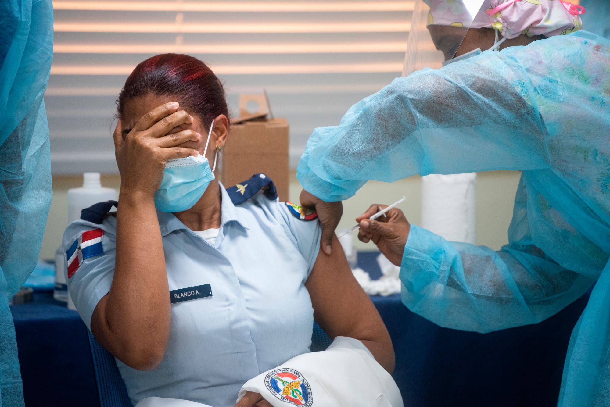 Una empleada del Hospital Militar Dr. Ramón de Lara se tapa los ojos mientras la vacunan contra el covid-19, el 16 de febrero de 2021.