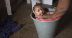 Una señora baña a su hijo que sufre microcefalia, enfermedad que está relacionada con el virus del Zika, transmitido por picadura de mosquito. (AP/Felipe Dana)
