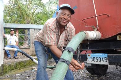 El propietario de un camión cisterna de agua se abastece para distribuir el líquido en uno de los puntos dispuestos por la Corporación de Acueductos de Santo Domingo (CAASD). 
