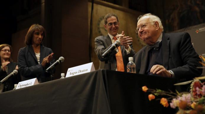 El economista británico-estadounidense Angus Deaton (d) es aplaudido por sus colegas durante una conferencia en Princeton, Nueva Jersey. 