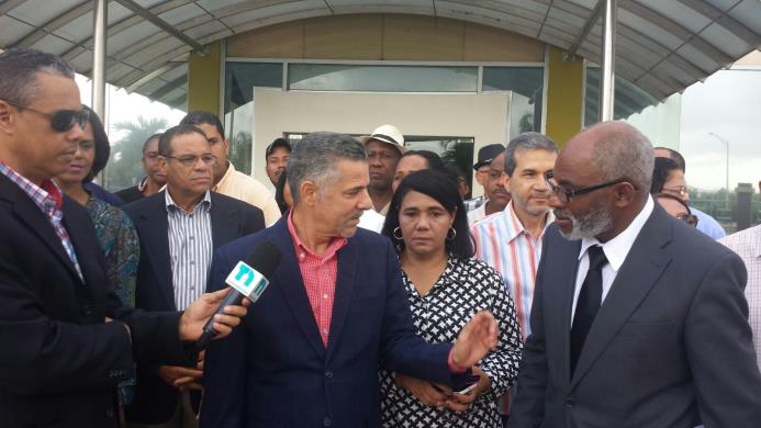 Manuel Jiménez, al centro, junto a su abogado a la salida de la Junta Municipal de Santo Domingo Este.