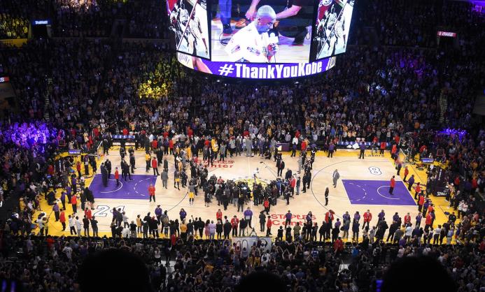 El jugador de los Lakers de Los Angeles Kobe Bryant habla a los aficionados luego del juego contra el Jazz de Utah, el 13 de abril de 2016, en Los Angeles.