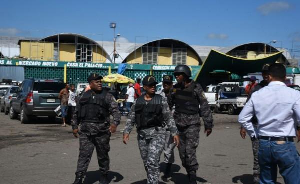 Policías custodian el Mercado Nuevo de la avenida Duarte.