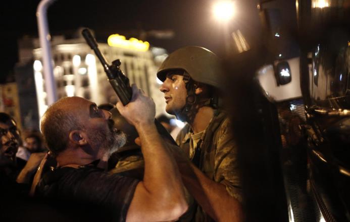 Un policía turco arresta a un soldado que formaba parte del levantamiento en la Plaza Taksim, en Estambul. 
