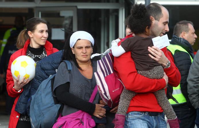 Viajeros abandonan un gimnasio donde recibieron refugio después de las explosiones, cerca del aeropuerto Zaventem en Bruselas, el martes 22 de marzo de 2016. 