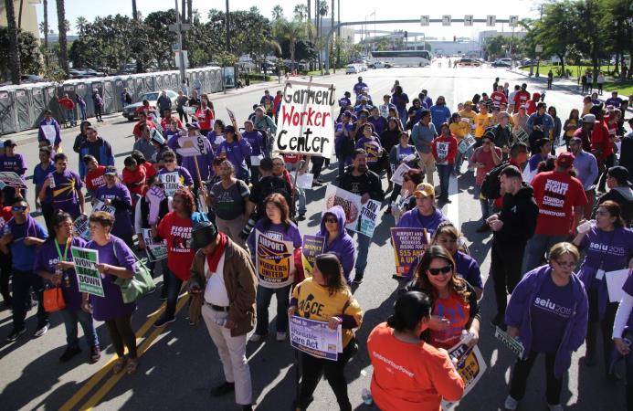 Un grupo de personas participa en una protesta para solicitar un aumento en el salario mínimo en el país, a las afueras del aeropuerto internacional de Los Ángeles, California, ayer 29 de noviembre de 2016. 