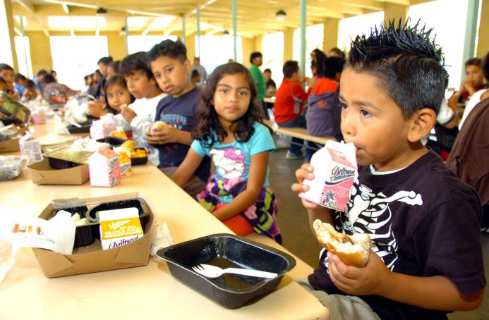 Varios estudiantes desayunan en un comedor de una escuela en Los Ángeles.