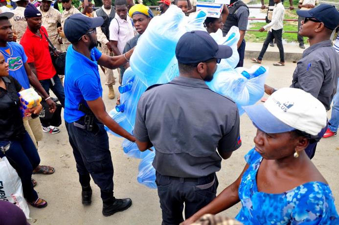 Autoridades haitianas se incautan de botellones plásticos ayer.