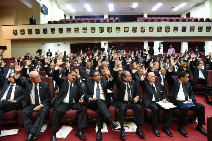Los asambleistas levantan sus manos con lo que aprueban proclamar a Danilo Medina y a Margarita Cedeños los ganadores de las elecciones presidenciales del pasado mes de mayo