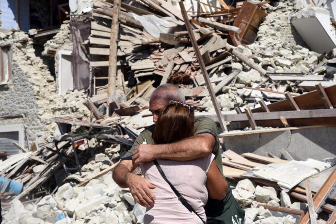 Dos lugareños se abrazan ante varias casas derrumbadas en Pescara del Tronto, cerca de la localidad de Arquata del Tronto, en la provincia de Ascoli Piceno, región de Marche, en el centro de Italia, hoy, 24 de agosto de 2016.
