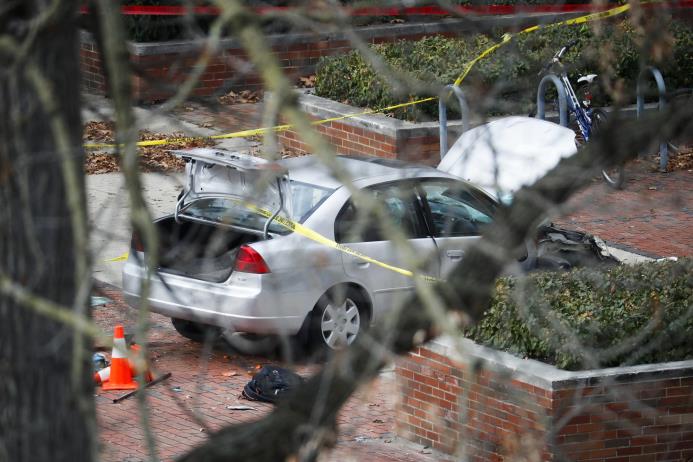 Un auto es rodeado por cintas de escena del crimen en una acera, mientras las autoridades responden a un ataque en el campus de la Universidad Estatal de Ohio el lunes 28 de noviembre de 2016 en Columbus, Ohio.