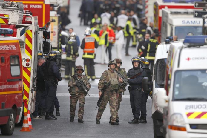 Agentes de policía y soldados aseguran una calle en el vecindario de Saint-Denis, en el norte de París, durante una operación policial contra supuestos participantes en los ataques perpetrados en la capital francesa la semana pasada, el 18 de noviembre de 2015. 