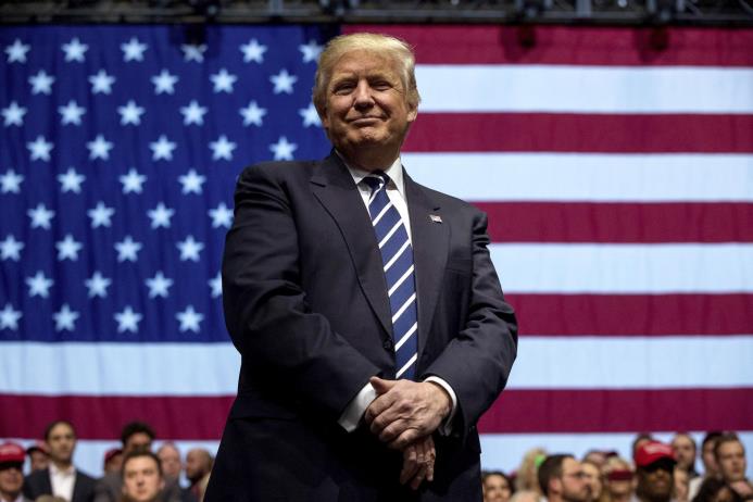 En esta fotografía del 9 de diciembre de 2016, el presidente electo Donald Trump sonríe durante un mitin en la Arena DeltaPlex en Grand Rapids, Michigan.