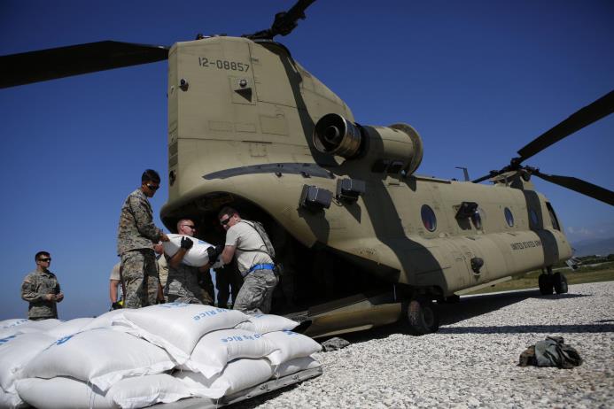 Efectivos militares estadounidenses cargan bolsas de arroz para víctimas del huracán Matthew en el aeropuerto de Puerto Príncipe, Haití, jueves 13 de octubre de 2016. 
