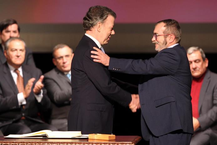 El presidente de Colombia Juan Manuel Santos (i) y el jefe máximo de las FARC Rodrigo Londoño Echeverry (d) se felicitan luego de firmar el nuevo acuerdo de paz.