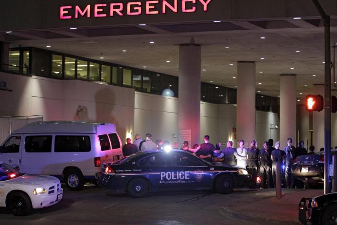 Agentes de la policía de Dallas y personal médico forman un cordón a la entrada del hospital Baylor Scott&White donde fue llevado el cadáver de uno de los cinco agentes muertos durante una manifestación contra la violencia policial hacia los negros hoy, 8 de julio de 2016. 