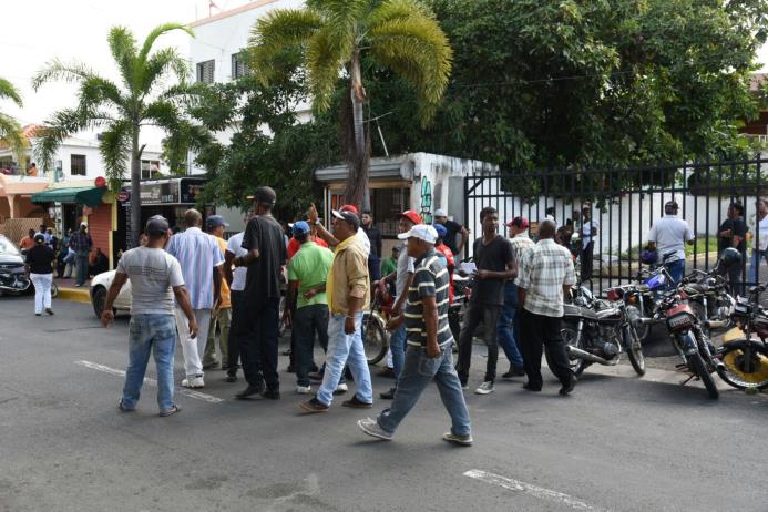 Exempleados caminan por los frentes del Ayuntamiento de Santo Domingo Norte.