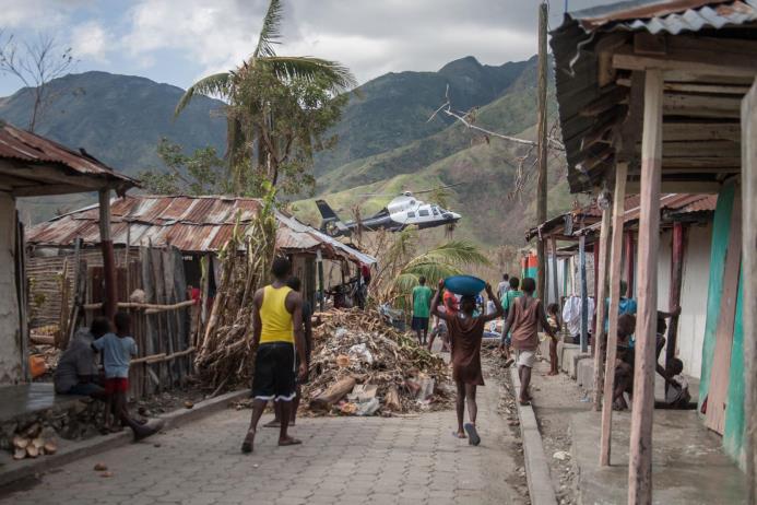 Personas caminan por una zona afectada luego del paso del huracán Matthew, en Tiburón (Haití). 