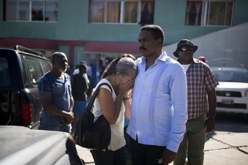 El político haitiano y excandidato presidencial Jude Celestin se encuentra con un pariente cuando la ambulancia con el cuerpo del expresidente haitiano René Préval llega al hospital Sainte Claire en Petion-Ville, Haití.