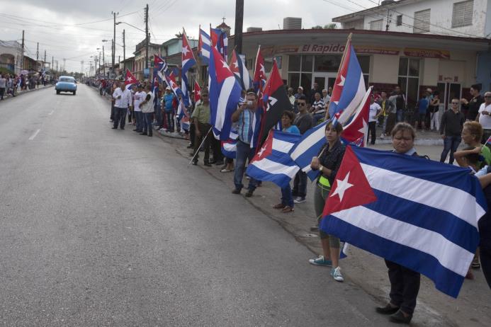 Multitud con banderas cubanas saluda el paso de la caravana que transporta las cenizas del líder cubano Fidel Castro a la salida de la ciudad de Santa Clara. 