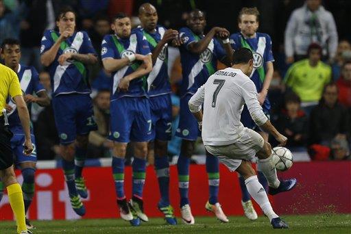 El jugador de Real Madrid, Cristiano Ronaldo, derecha, anota un gol de tiro libre contra Wolfsburgo por la Liga de Campeones el martes, 12 de abril de 2016