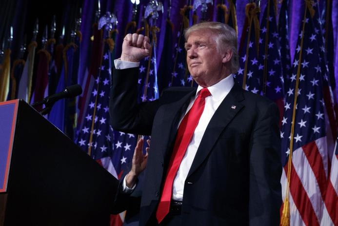 El presidente electo Donald Trump alza el puño durante los festejos de su victoria, miércoles 9 de noviembre de 2016. 