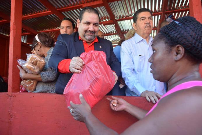 Ramón Rogelio Genao entrega fundas con alimentos.
