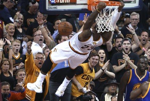 Los espectadores gritan mientras LeBron James, de los Cavaliers de Cleveland, realiza una clavada en el sexto partido de la final de la NBA