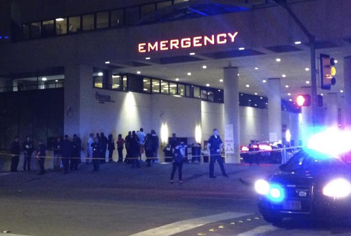 Policías y otras personas congregadas a la entrada de la unidad de urgencias del centro médico Baylor en Dallas, donde varios agentes fueron ingresados.