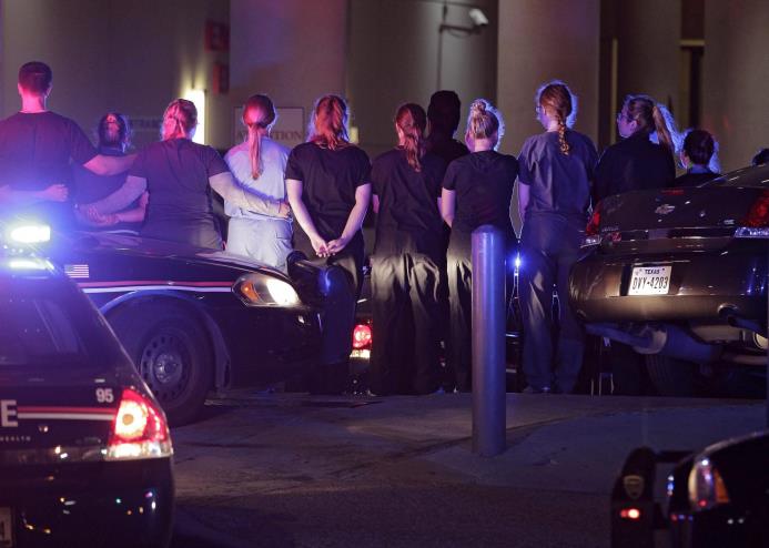 DALLAS (Estados Unidos). Agentes de la policía de Dallas y personal médico forman un cordón a la entrada del hospital Baylor Scott&White, donde fue llevado el cadáver de uno de los cinco agentes muertos durante una manifestación contra la violencia policial hacia los negros. 
