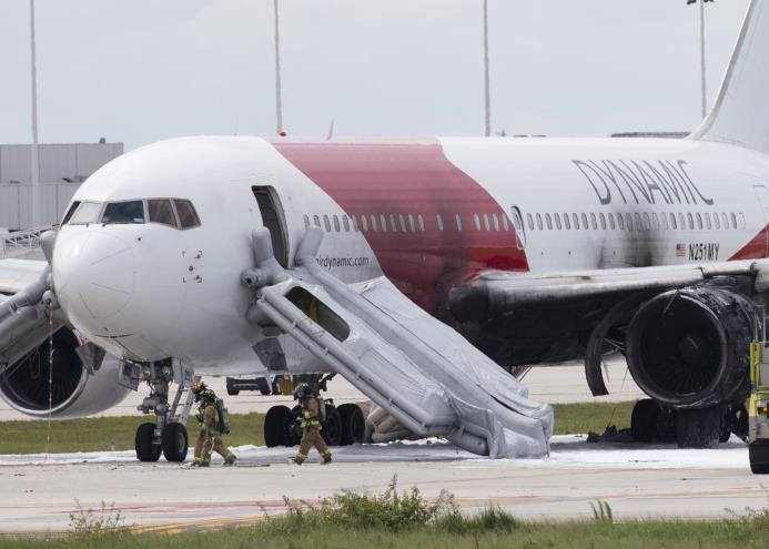 Los bomberos pasan junto a una dinámica Airways Boeing 767, en el Aeropuerto Internacional de Fort Lauderdale.