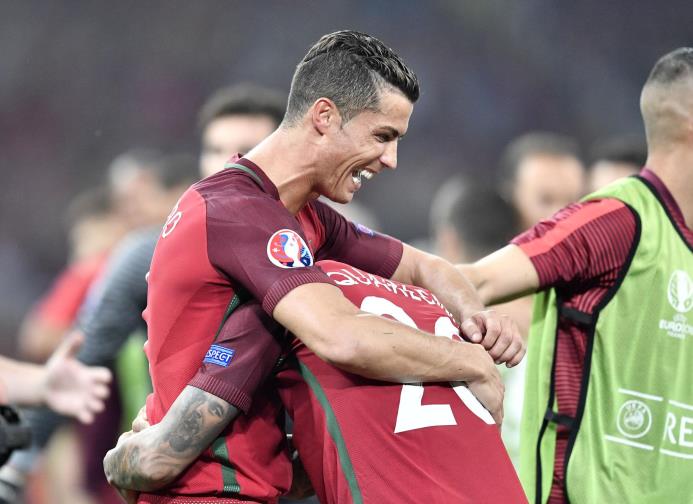 Cristiano Ronaldo y su compañero Ricardo Quaresma, quien marcó el último punto en la tanda de penales, celebran el avance de Portugal sobre Polonia en la Eurocopa, 2016.