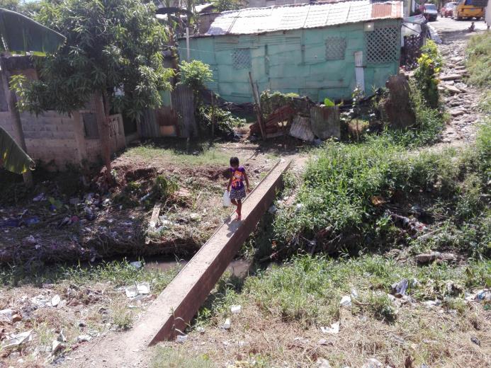 Una niña cruza una estructura improvisada por el sector.