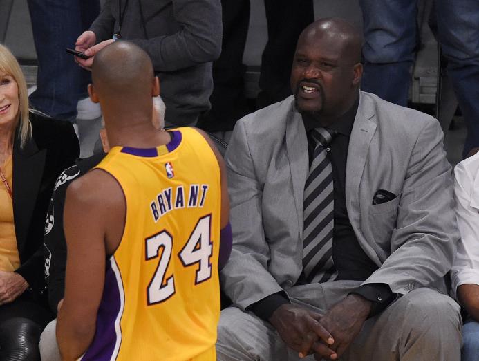 Shaquille O’Neal (derecha) habla con el jugador de los Lakers de Los Angeles Kobe Bryant durante la primera parte del juego de la NBA contra el Jazz de Utah, el último de su carrera como profesional, el 13 de abril de 2016, en Los Angeles.
