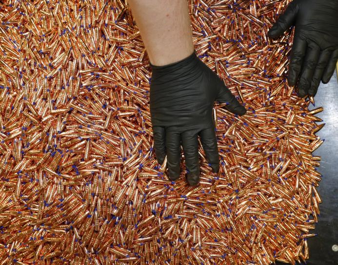 Imagen de archivo de un trabajador de una empresa de fabricación de balas en Utah, Estados Unidos, lavando y sacando brillo a balas de cobre. 