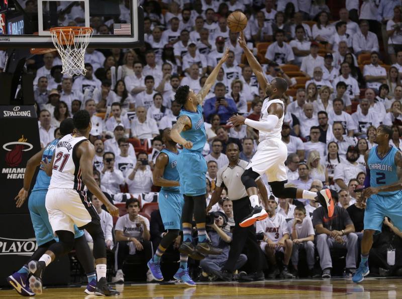 Dwyane Wade, del Heat de Miami, dispara frente a Courtney Lee, de los Hornets de Charlotte, en el segundo encuentro de su serie de primera ronda de postemporada.