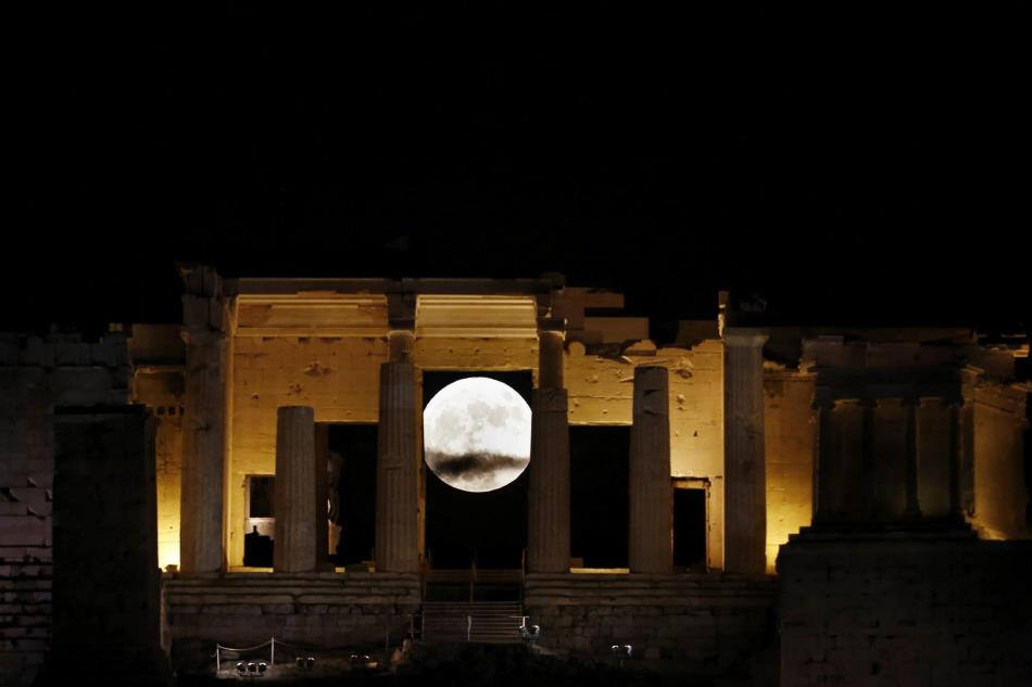 La superluna se eleva tras el propileo de la antigua Acrópolis en Atenas
