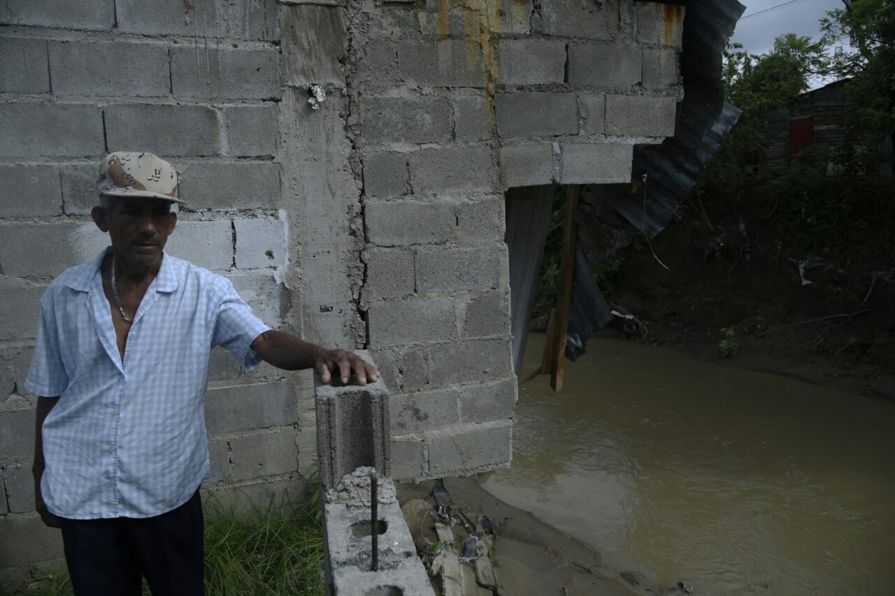 Un hombre al lado de una vivienda del barrio Duarte, en la comunidad de Cienfuegos, afectada por las lluvias.