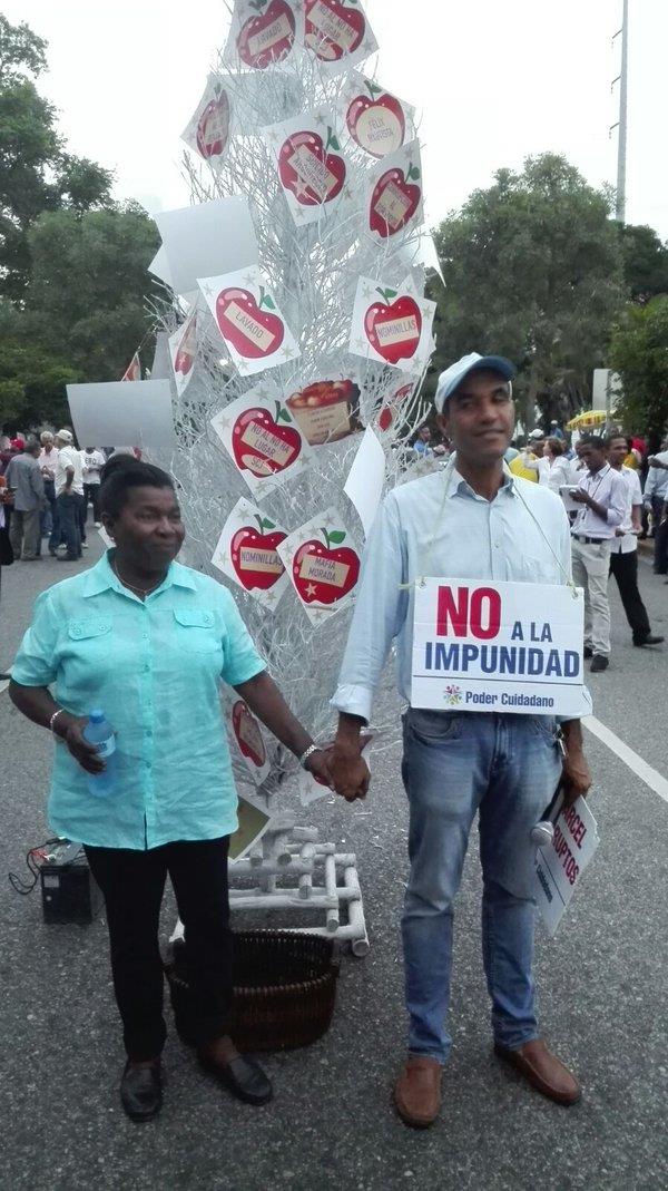 Manifestantes contra la OISOE llevan arbolito con mensajes contra la corrupción 