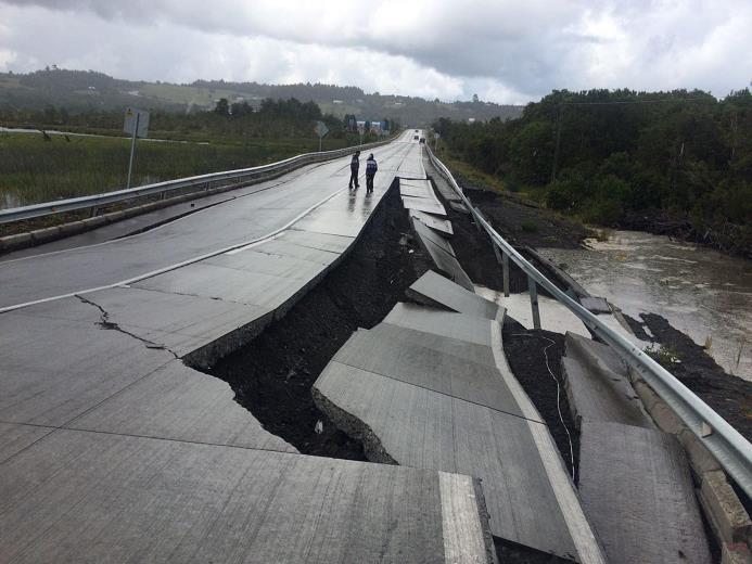 CHILOE (Chile). Personas caminan por una carretera destruida hoy, domingo 25 de diciembre de 2016, en Tarahuin, en la isla de Chiloe. Las autoridades emitieron una alerta de tsunami y ordenaron evacuar las zonas costeras en cinco regiones tras registrarse un terremoto de magnitud 7,6.